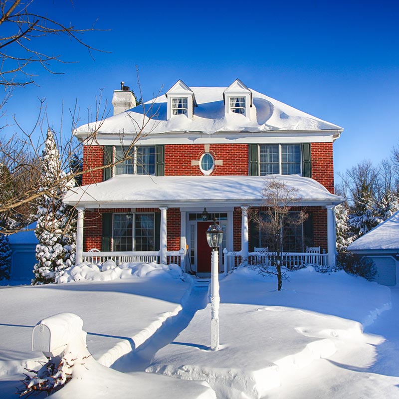 Snow covered brick house in CT